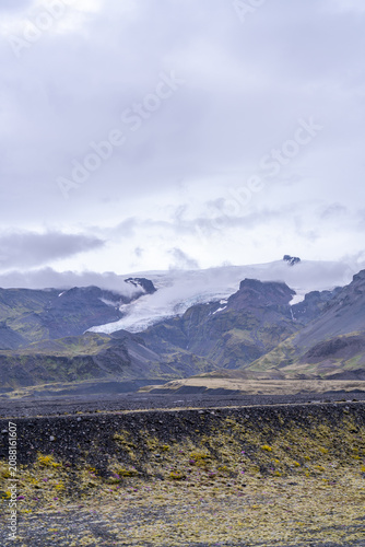 Obraz na płótnie Glacier tongue descending between mountains above a black moss plain, Iceland