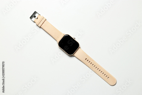 Modern smartwatch with a cream silicone strap and black touchscreen display laid flat on a clean white background