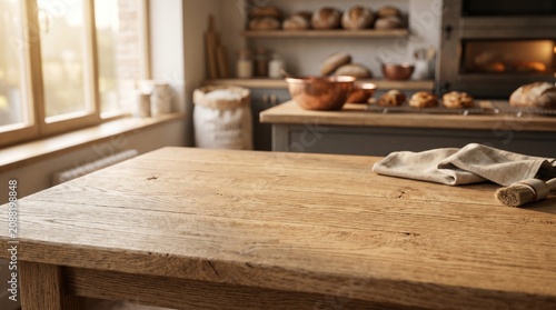 A rustic wooden kitchen table sits in a sunlit bakery. Fresh bread, copper bowls, and baking tools are visible in the blurred background.