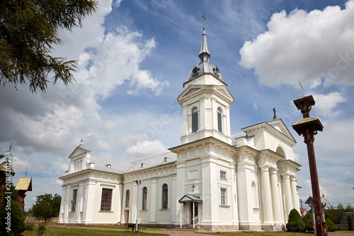 Fotografi White stone Church of the Holy Trinity in Indura stands as monument of late classicism with neobaroque and neoclassic elements