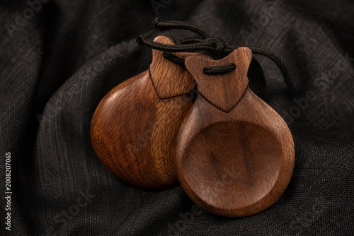 Canvas Print Traditional flamenco castanets resting on dark textured fabric.