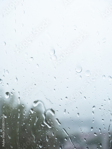 Water Droplets on Window Glass Against Bright Overcast Background