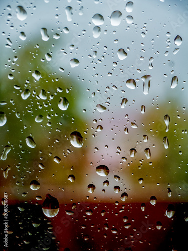 Raindrops on Window Glass With Blurred Green Outdoor Background