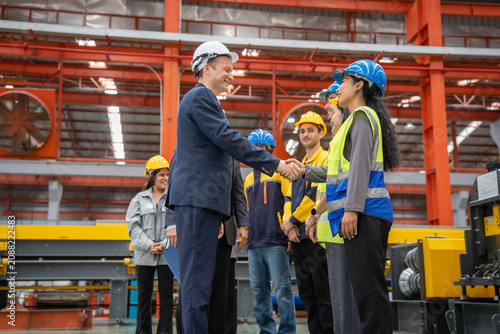 Business leaders engaging with workers in a manufacturing facility to foster collaboration and safety