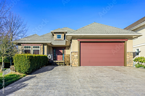 Modern Suburban House Exterior with Red Garage Door and Stamped Concrete Driveway
