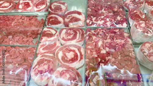 Fresh Meat Display at a Grocery Store Counter.Glass-Topped Refrigerated Meat Counter with Various Cuts of Meat in a Supermarket