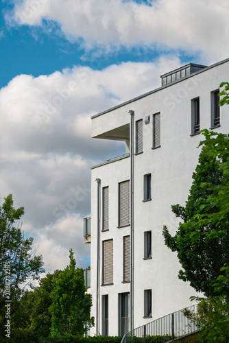 Sommerhitze auch im Wohnungsbau exklusiven Neubau, Rolladen unten und Wolkenhimmel am Stadtrand