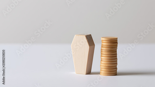 Minimalist representation of life's financial end: a light wood coffin figure beside a tall stack of round wooden tokens on a clean white surface