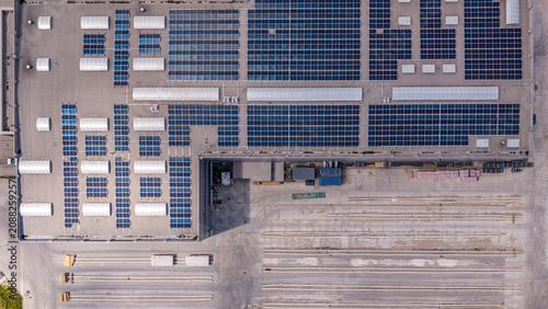 Aerial Top View of Industrial Warehouse Roof with Solar Panels and Sustainable Energy System