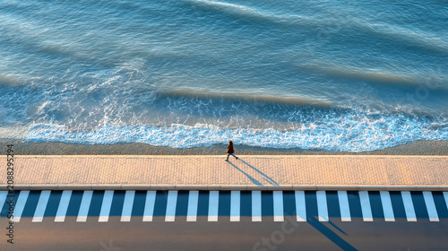 Aerial Coastal Promenade with Ocean Waves and Pedestrian