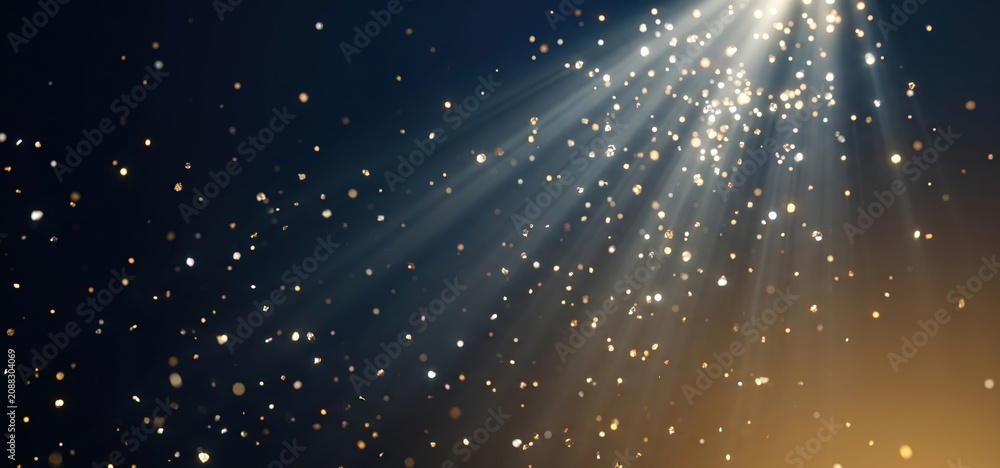 Fototapeta premium Golden sparkles and light rays descending from above against a dark blue and gold gradient background creating a magical effect
