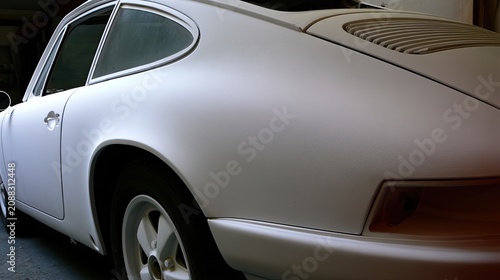 Close-up rear quarter panel view of a classic white coupe, detailed