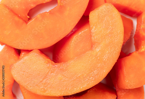 Pile of fresh ripe papaya chunks on a black background. Top view