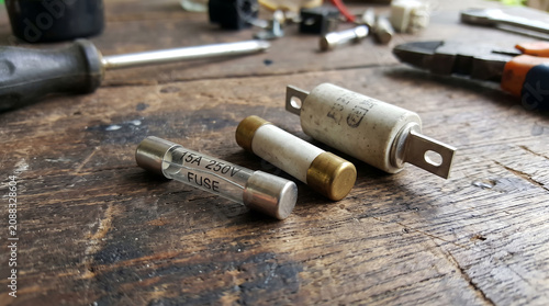 Assorted Electrical Fuses and Hand Tools on a Rustic Wooden Workbench for Electronic Repair