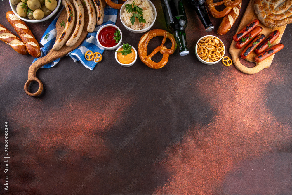 Fototapeta premium Oktoberfest picnic and barbecue food, bavarian party menu, bavarian sausages, pretzels, potato, sauerkraut, beer bottles, with picnic basket, checkered napkin tablecloth, Oktoberfest festive ribbon
