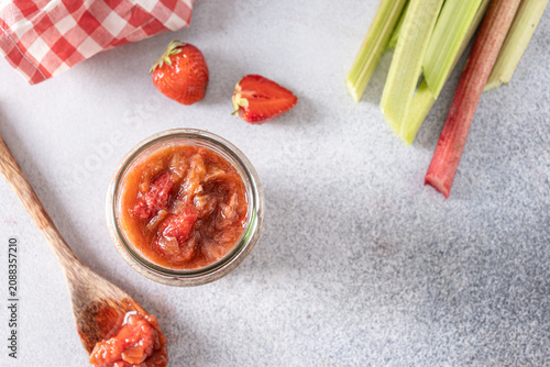 Homemade strawberry rhubarb jam in glass jar with copy space