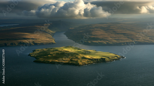Aerial view of a small green island separated from mainland by a deep dark blue channel.