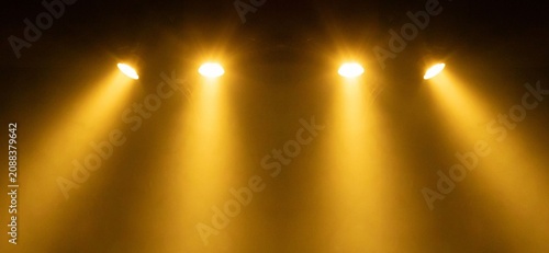 Fotografía Four warm spotlights pierce darkened air
