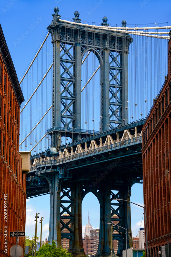 Fototapeta premium A view through a street canyon in Brooklyn (Dumbo) of a section of the world-famous Manhattan Bridge in New York (USA)