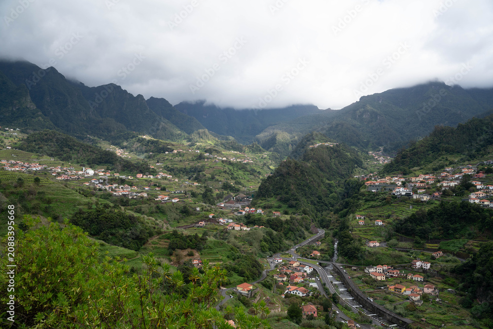 Fototapeta premium Santana, Madeira, Portugal. Charming rural village known for its traditional triangular thatched houses, lush green landscapes, scenic mountain views, and rich cultural heritage. A picturesque destina