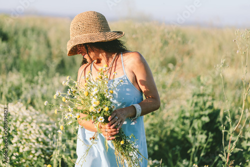 Woman holding wildflower bouquet in meadow