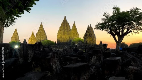 Timelapse of Prambanan Temple during sunset, capturing the transition from late afternoon to night. The changing sky, warm golden light, and illuminated temple create a dramatic and iconic cultural la