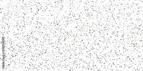 Fotografía A high-angle shot of scattered black dots on a white background, creating a textured, abstract pattern