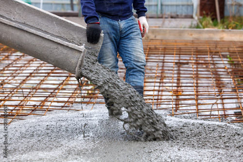 Closeup shot of concrete casting on reinforcing metal bars of floor in industrial construction site