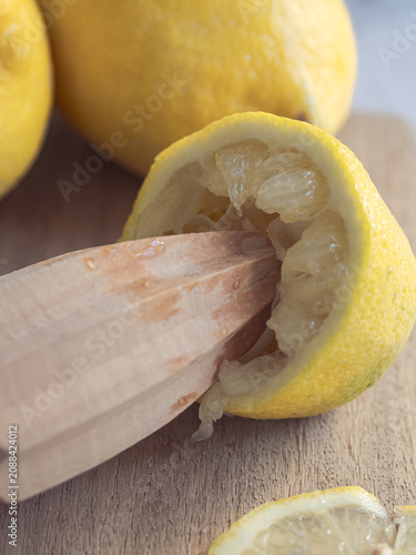 Принти на полотні lemons squeezed with a wooden reamer on a wooden board
