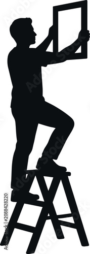 Silhouette of a man on a stepladder hanging a picture frame on a checkered background.