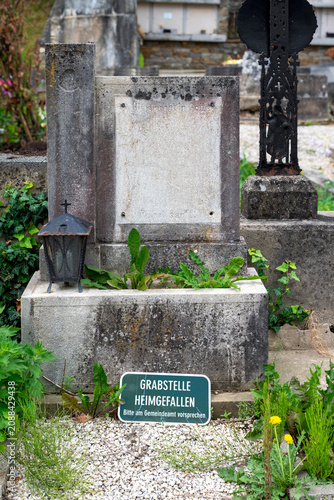 Abandoned, dilapidated, and unmarked old grave plot in an Austrian village cemetery