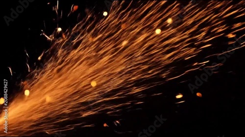 Orange sparks flying against black background
