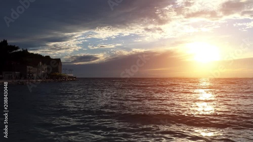 PRIMOSTEN, CROATIA - JULY 25 2017: Primosten (Capocesto) is village and municipality in Sibenik-Knin County, Croatia on Adriatic coast. Evening sun sinks into sea at sunset of day.