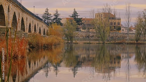 Masonry Pointed arch Stone bridge (Puente de Piedra) across the river Duero in Zamora, Castile-Leon, Spain. Reflection in the water.