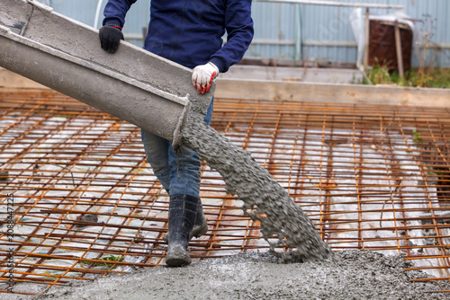 Closeup shot of concrete casting on reinforcing metal bars of floor in industrial construction site