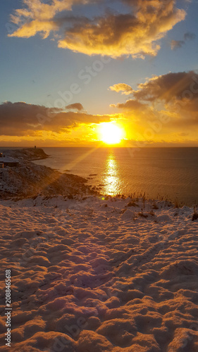 Bild auf Leinwand A stunning sunrise casts golden light over a snowy coastline in the Kuril Islands