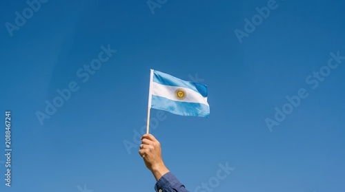 hand holding Argentina flag on nature background. 9th July of Independence day, 25th May of Revolution day and happy celebration concepts
