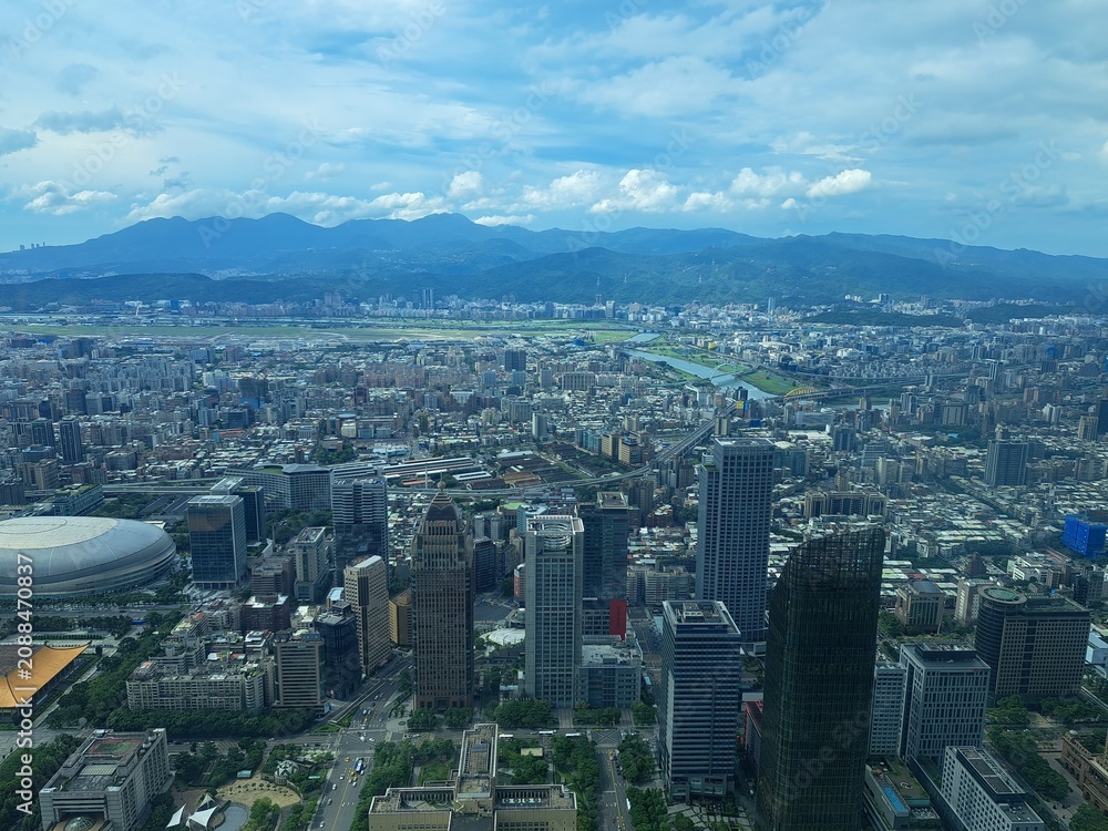 Fototapeta premium Aerial view of a dense modern cityscape with mountains in background