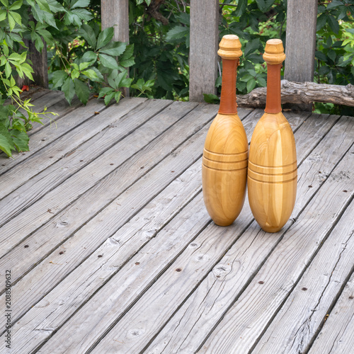 фотографія pair of Indian exercise clubs on a wooden deck - functional fitness concept, clu