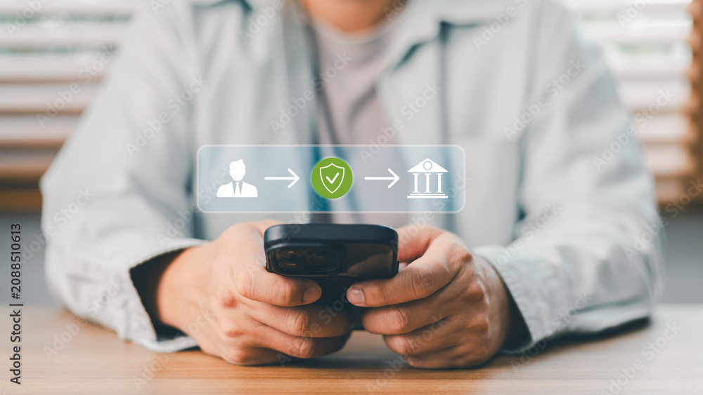 Naklejka premium Close up of person holding smartphone doing secure online mobile banking transaction. Financial technology icon showing safe money transfer from user to bank institution