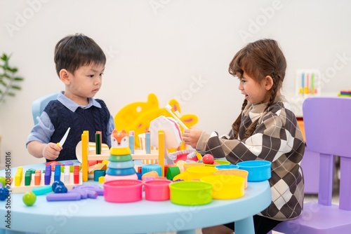 Children play with colorful toys at a table during a group activity in a learning center
