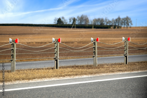Roadside rope fences stretch across open fields. Selective focus