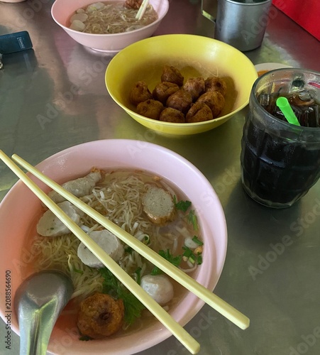noodle soup. Thai noodle soup. Thai food. Asian food. Braised beef. Frish meatballs. Noodles. Hot broth. Chopsticks. Homemade food. Bowl of noodles. Comfort food.