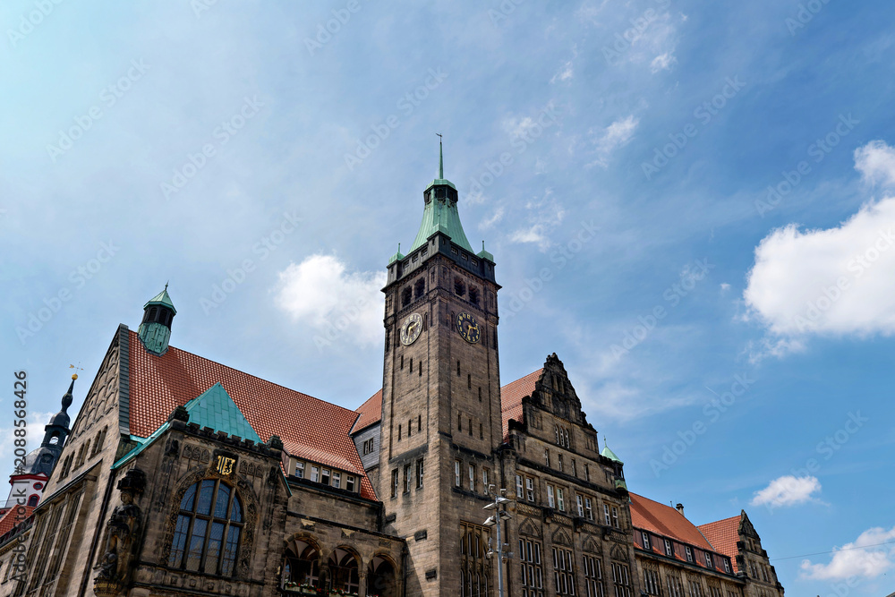 Obraz premium Historical town hall building with a prominent clock tower under a blue sky