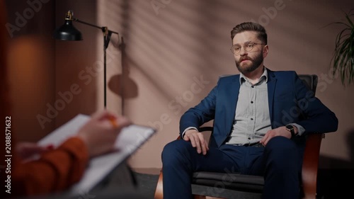 Casting director conducting audition for actors. Man auditioning in casting room. Male actor auditioning for main role. Movie producer holding folder. Actor and director having discussion.