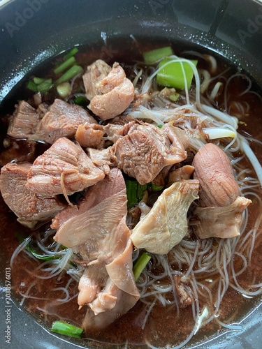 Beef noodle soup. Thai noodle soup. Thai food. Asian food. Braised beef. Beef meatballs. Noodles. Hot broth. Chopsticks. Homemade food. Bowl of noodles. Comfort food.