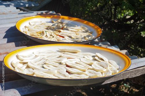 Quadro em tela Sunlit plates hold sliced bananas