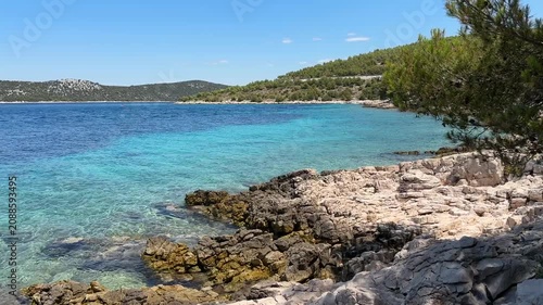 Enjoying the clear water and rocky shore at a Croatian beach on a sunny day