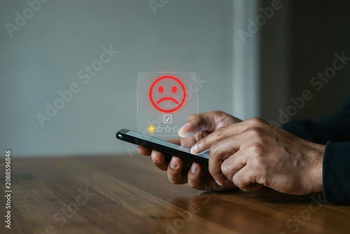Customer using smartphone to give one star negative rating feedback for bad service quality