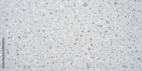 White terrazzo stone floor texture background with grey and black mineral chips and marble fragments.